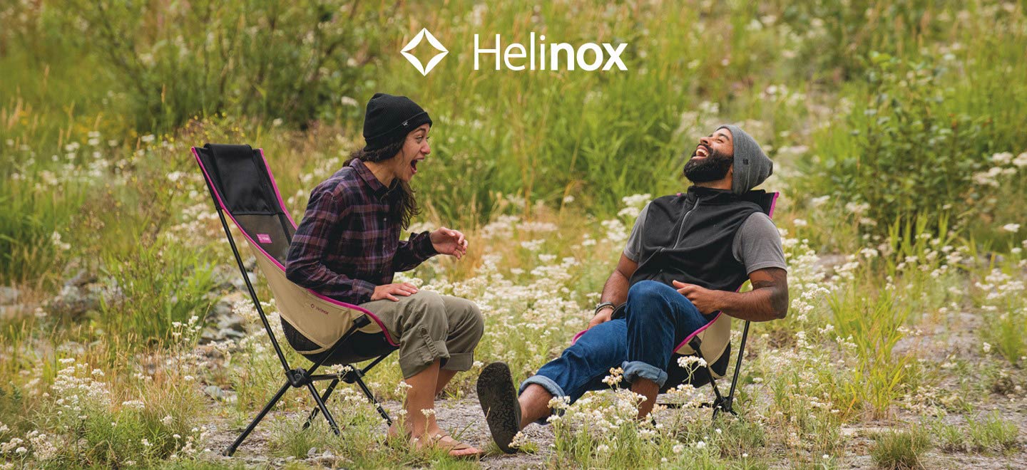 two campers sitting on helinox chairs laughing